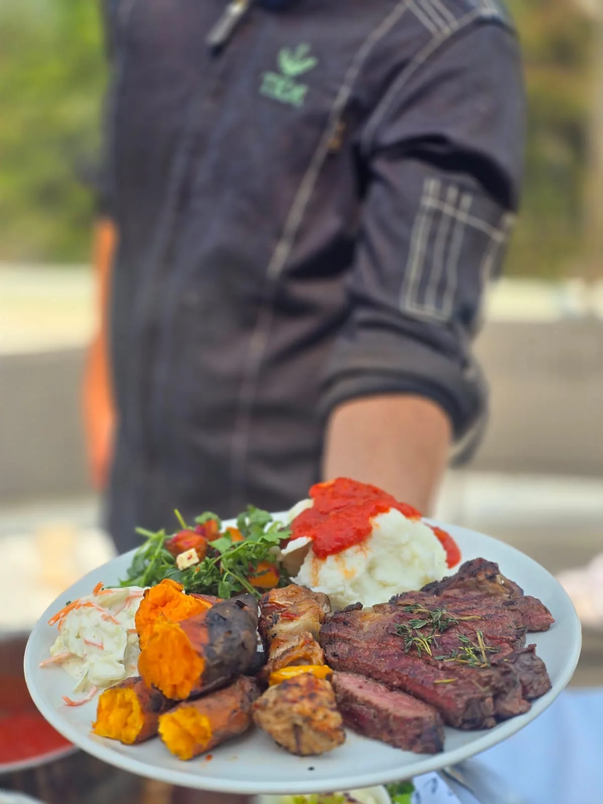 Chef presenting a plated braai meal
