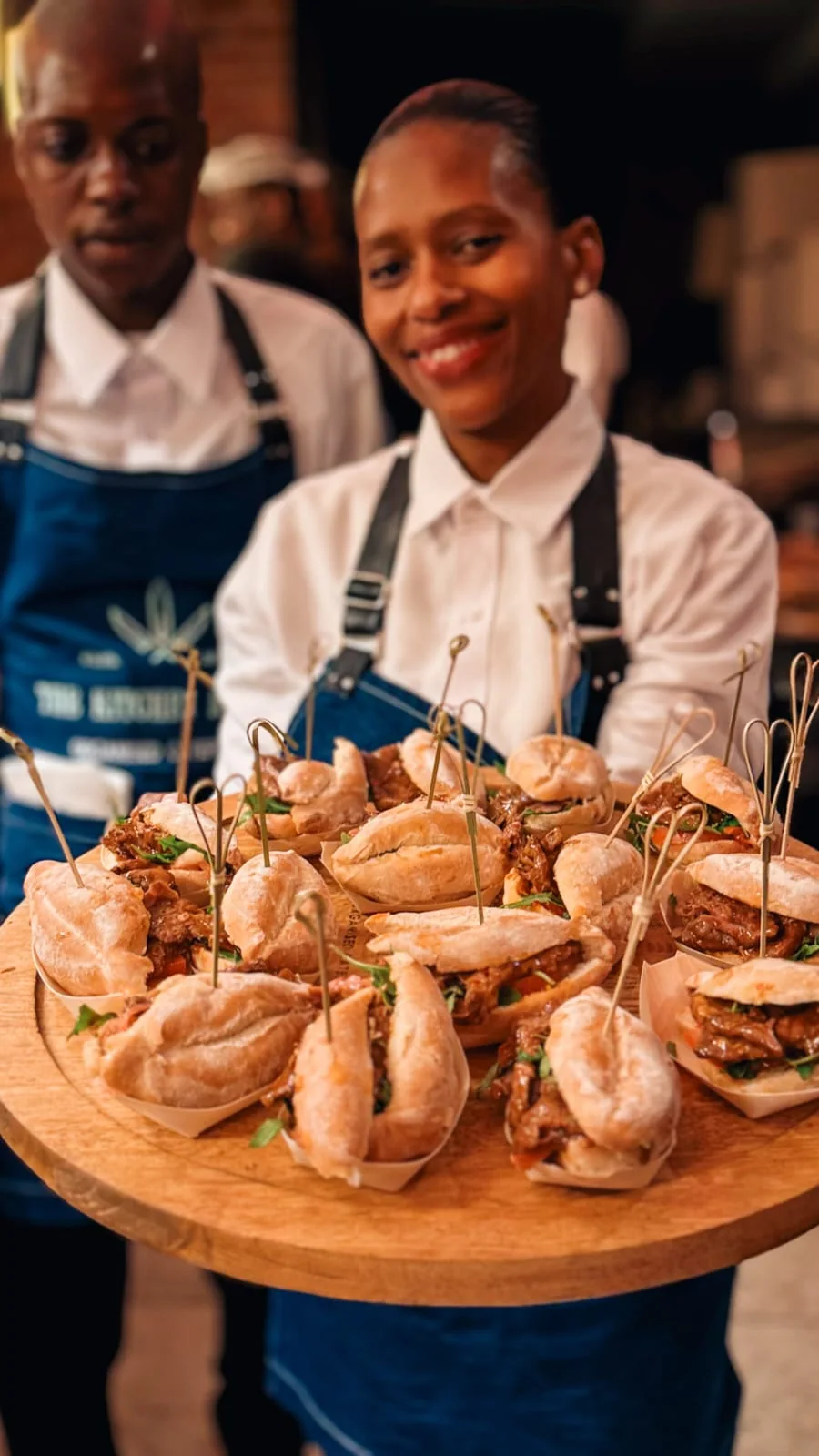 Catering staff member presenting a tray of canapés